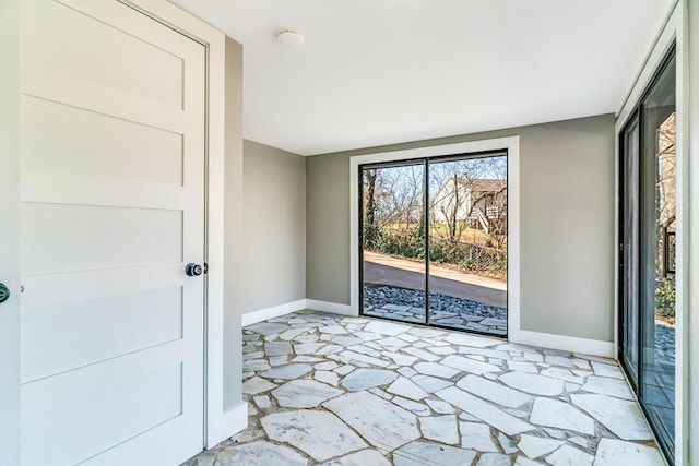 empty room with stone finish floor and baseboards