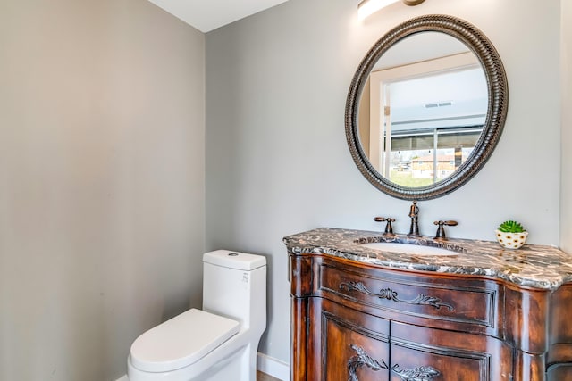 half bath with vanity, toilet, and visible vents