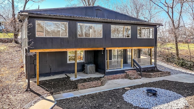 rear view of property with cooling unit, a patio area, and covered porch