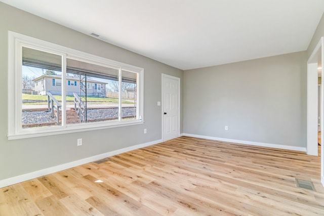 spare room featuring visible vents, baseboards, and wood finished floors