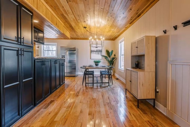 kitchen featuring light wood-style floors, wood ceiling, stainless steel refrigerator with ice dispenser, pendant lighting, and a chandelier