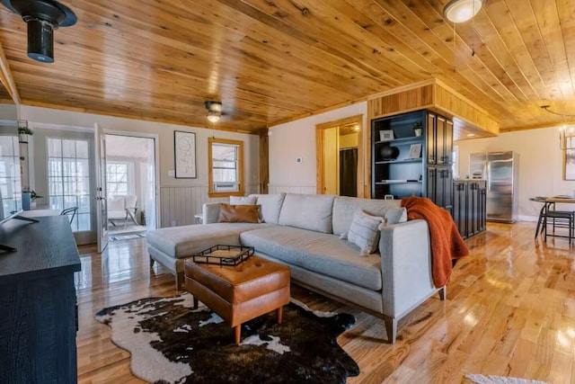 living area featuring a wainscoted wall, wood ceiling, and light wood-type flooring