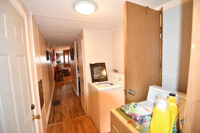 laundry room with laundry area, visible vents, light wood-type flooring, and washer and clothes dryer