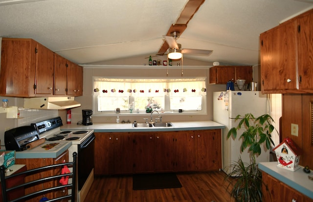 kitchen featuring a sink, under cabinet range hood, electric range oven, freestanding refrigerator, and light countertops