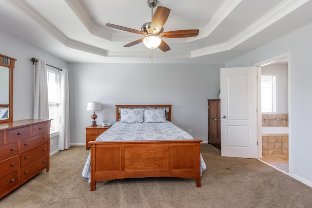 bedroom featuring baseboards, crown molding, ensuite bathroom, a raised ceiling, and light colored carpet