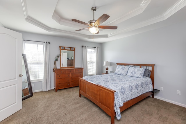 bedroom with light colored carpet, a raised ceiling, baseboards, and ornamental molding