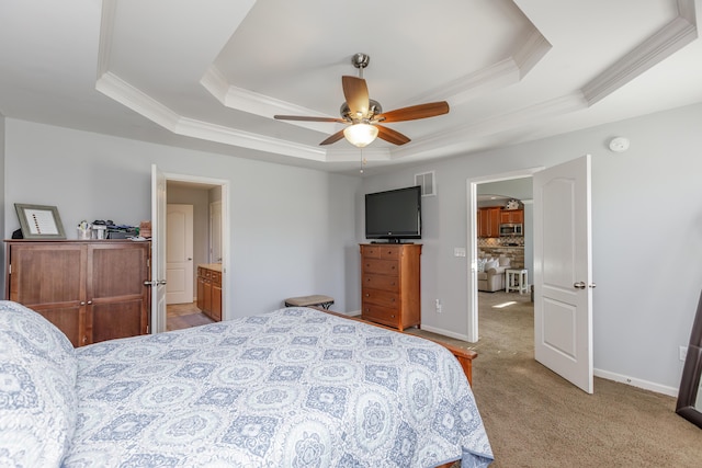 bedroom with visible vents, baseboards, light colored carpet, a tray ceiling, and ornamental molding