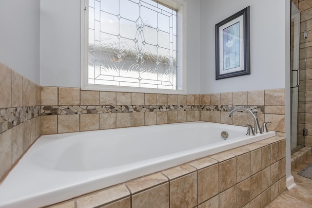 full bathroom featuring a bath and a shower stall