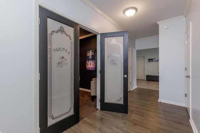 interior space with baseboards, wood finished floors, and ornamental molding