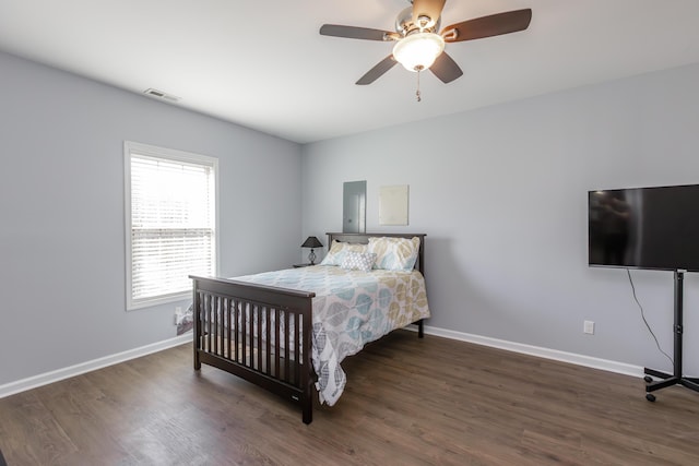 bedroom with ceiling fan, wood finished floors, visible vents, and baseboards