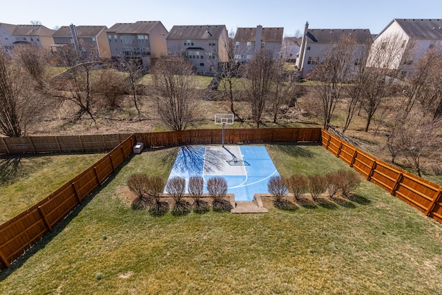 exterior space featuring basketball hoop, a yard, a fenced backyard, and a residential view