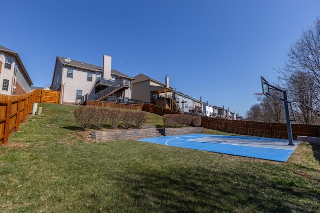 view of sport court with a lawn, a fenced backyard, and basketball court