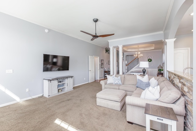 living room featuring baseboards, ornate columns, carpet floors, crown molding, and ceiling fan with notable chandelier