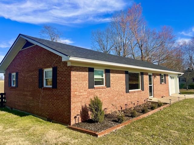 view of property exterior with brick siding, a yard, and a garage