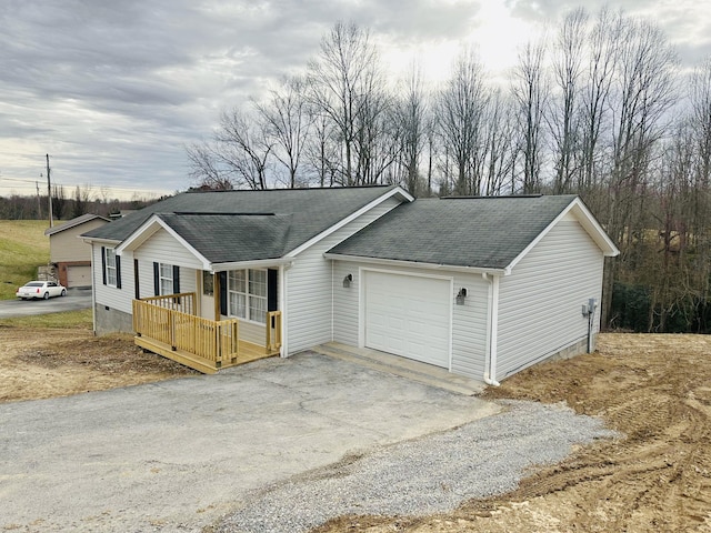 view of front of house with aphalt driveway, a garage, and a shingled roof