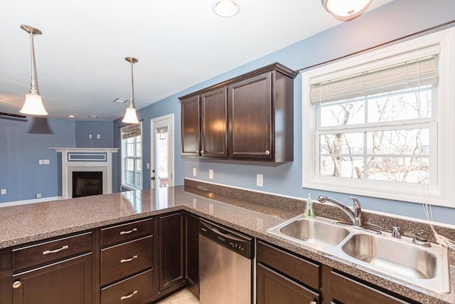 kitchen with a sink, dark brown cabinetry, a fireplace, dishwasher, and hanging light fixtures