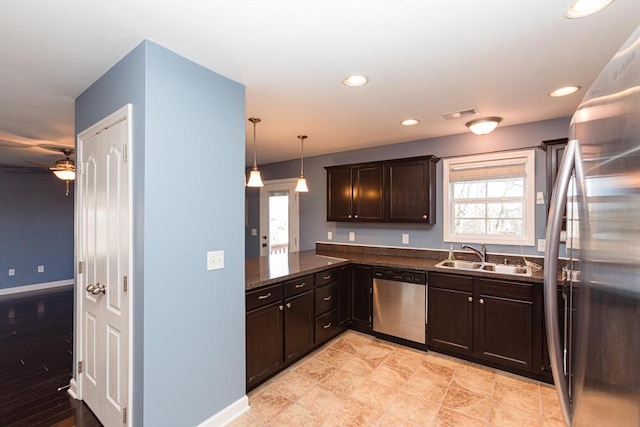 kitchen with visible vents, a sink, stainless steel appliances, dark brown cabinetry, and baseboards