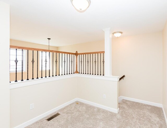 hallway with visible vents, baseboards, and carpet