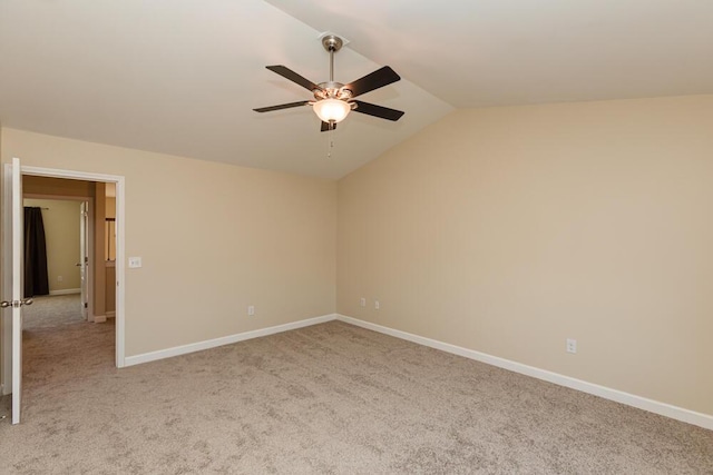 empty room featuring light carpet, ceiling fan, baseboards, and lofted ceiling