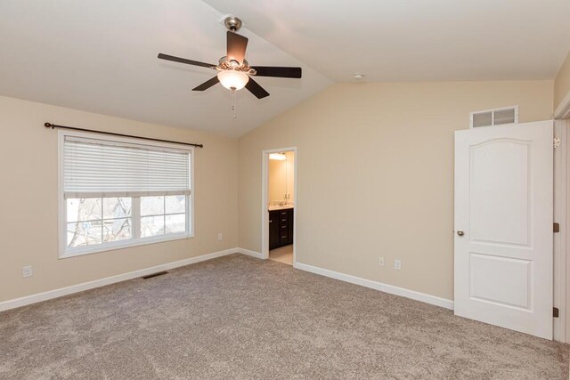 unfurnished bedroom featuring vaulted ceiling, light colored carpet, visible vents, and baseboards