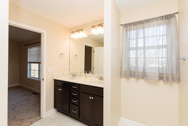 full bathroom featuring double vanity, baseboards, marble finish floor, and a sink