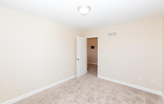 unfurnished room featuring visible vents, carpet, and baseboards