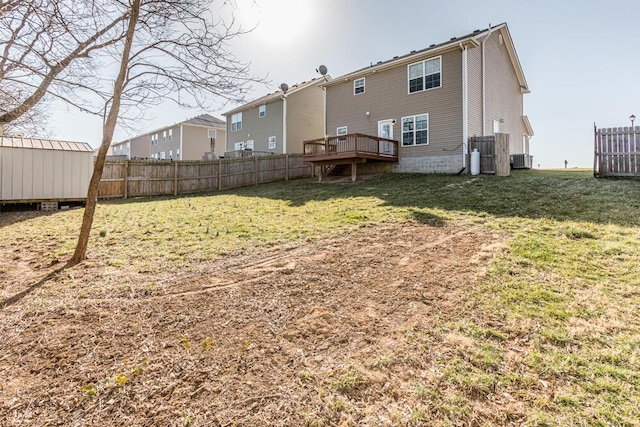 rear view of property with an outdoor structure, a yard, fence, and a storage unit