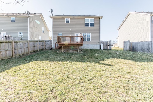 back of house featuring a fenced backyard, a lawn, and a deck