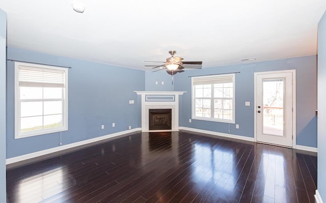 unfurnished living room with a fireplace with flush hearth, ceiling fan, baseboards, and wood finished floors