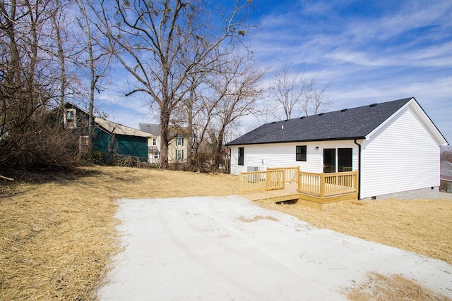 rear view of house with a deck, a shingled roof, and crawl space