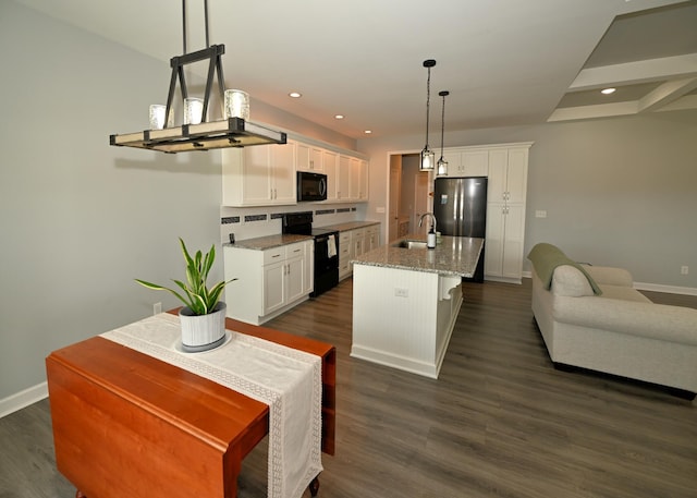 kitchen with a sink, black appliances, dark wood-style flooring, and white cabinetry