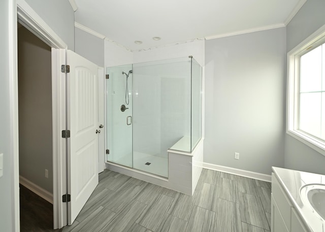 full bath with a shower stall, vanity, crown molding, and baseboards