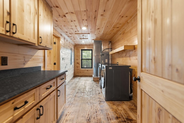 laundry room with wood ceiling, wooden walls, washing machine and dryer, and light wood-type flooring