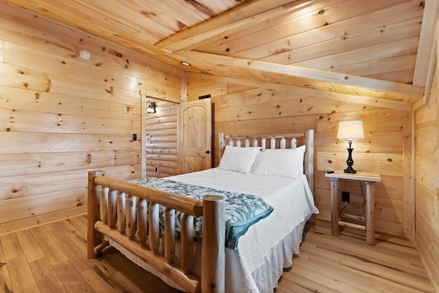 bedroom with lofted ceiling with beams, light wood-style flooring, wooden walls, and wood ceiling