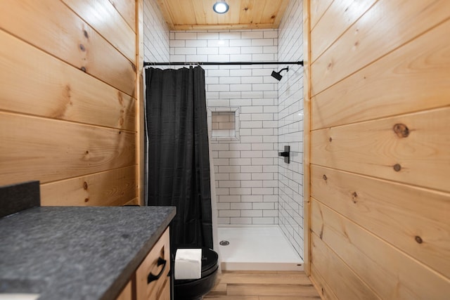 full bath featuring wood walls, a stall shower, and toilet