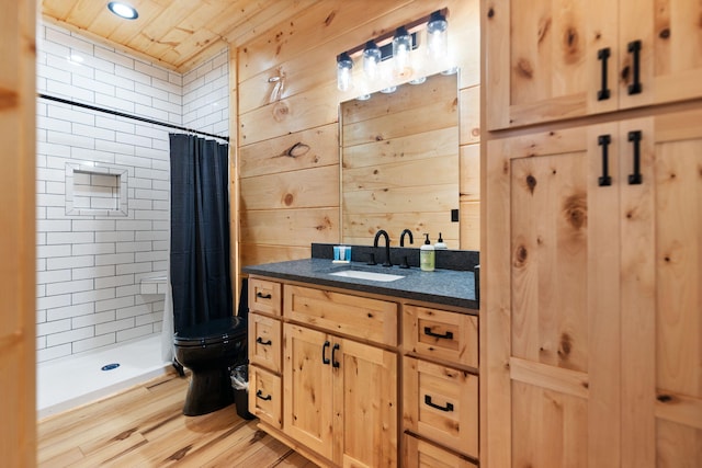 full bath featuring wooden walls, a shower stall, toilet, and wood finished floors