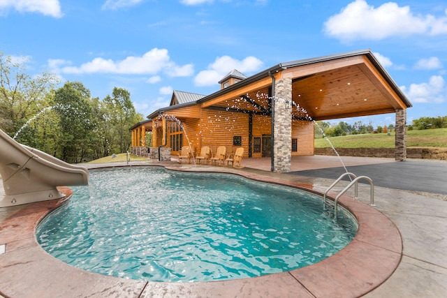 outdoor pool with a patio and a water slide