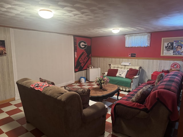 living area featuring tile patterned floors, a wainscoted wall, and wood walls