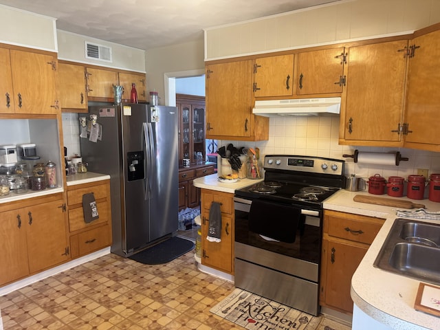 kitchen featuring visible vents, under cabinet range hood, stainless steel appliances, light countertops, and decorative backsplash