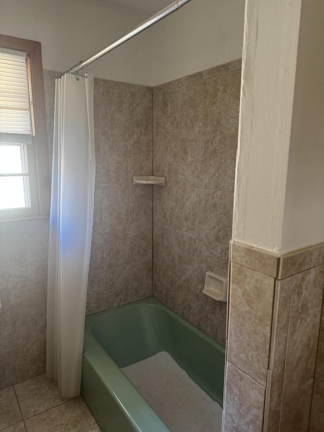 full bathroom featuring tile patterned floors, shower / tub combo with curtain, and tile walls