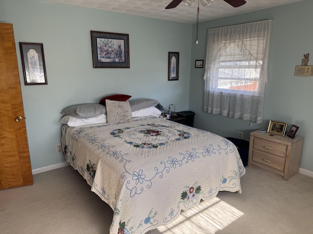 bedroom with a ceiling fan, light colored carpet, and baseboards