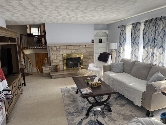 living area featuring stairs, carpet floors, and a fireplace