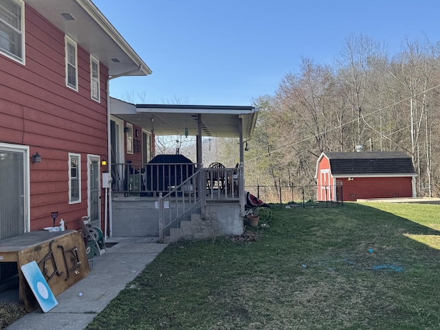 view of yard featuring an outbuilding, a storage unit, and fence