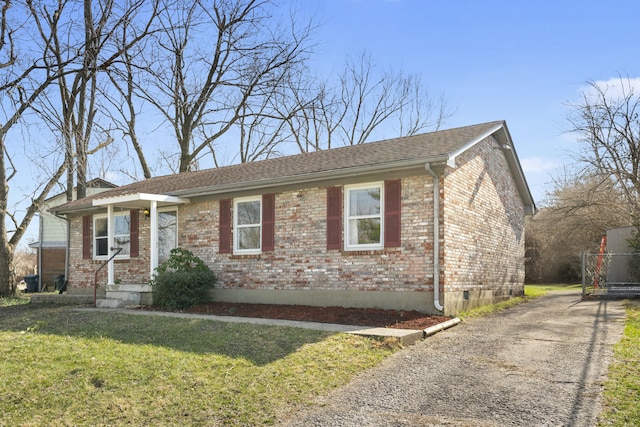 view of front of house featuring driveway, brick siding, and a front yard