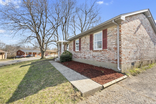 view of side of home with a yard and brick siding