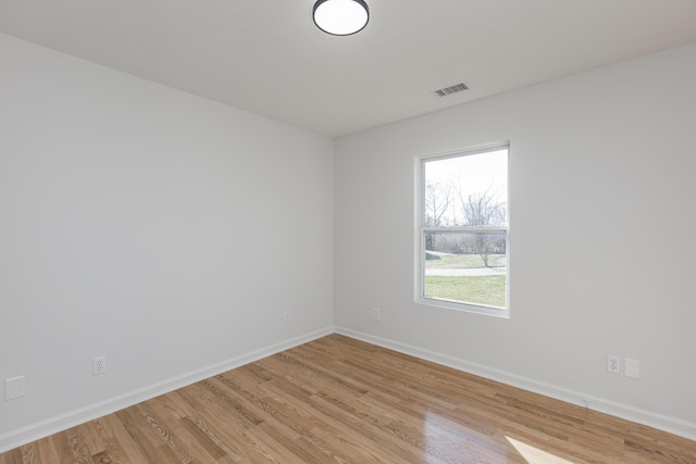 empty room featuring visible vents, baseboards, and light wood-style floors