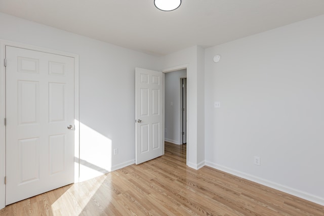 unfurnished bedroom featuring light wood-type flooring and baseboards