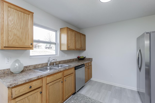 kitchen with light floors, stainless steel appliances, baseboards, and a sink