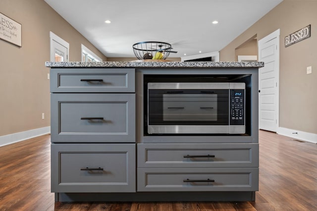 details with recessed lighting, stainless steel microwave, baseboards, and wood finished floors