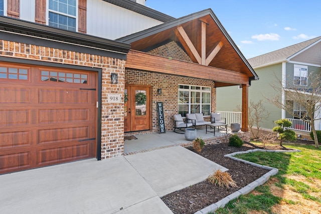 view of exterior entry with brick siding and a porch